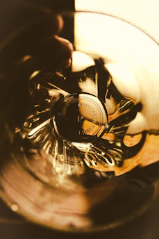 A close-up of a glass cup with intricate patterns reflecting light