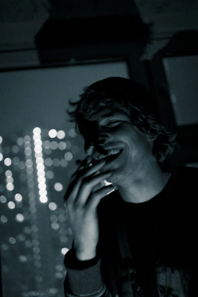 A vibrant social media influencer caught mid-laugh with colorful city lights behind.