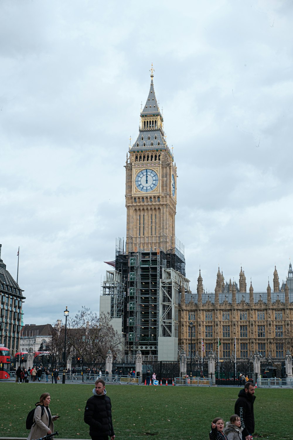 people sitting on a bench in front of a clock tower