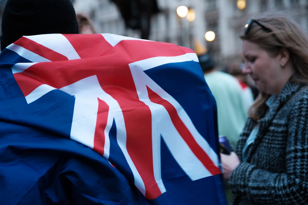 a woman holding a british flag in a crowd of people