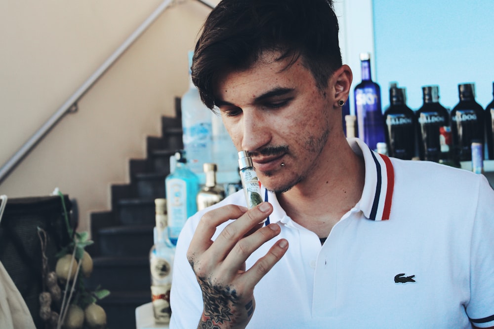 a man in a white shirt smoking a cigarette