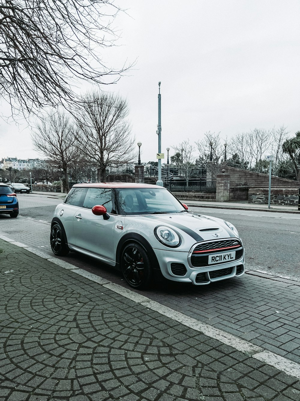 a small silver car parked on the side of the road