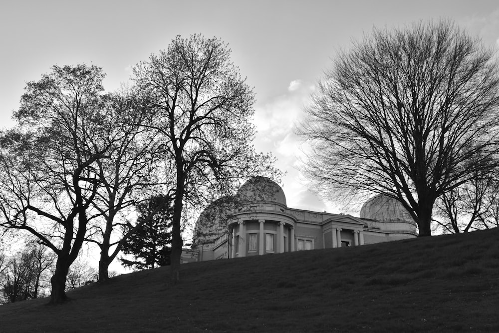 a black and white photo of a building on a hill