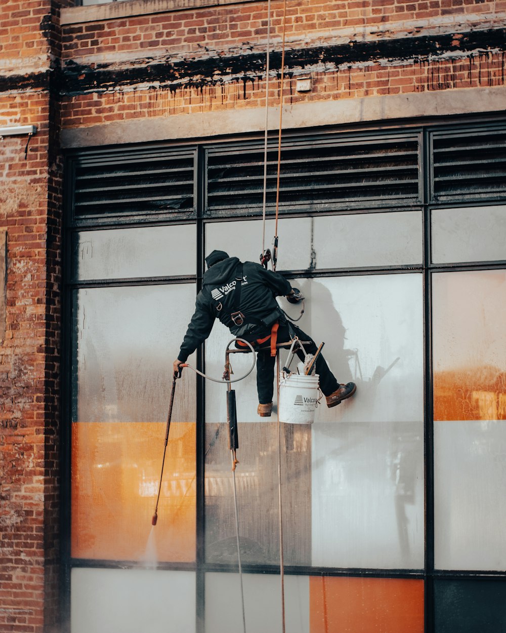 a man hanging from a rope on the side of a building