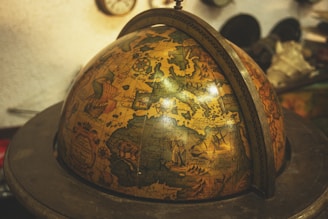 a globe on a stand with a clock in the background