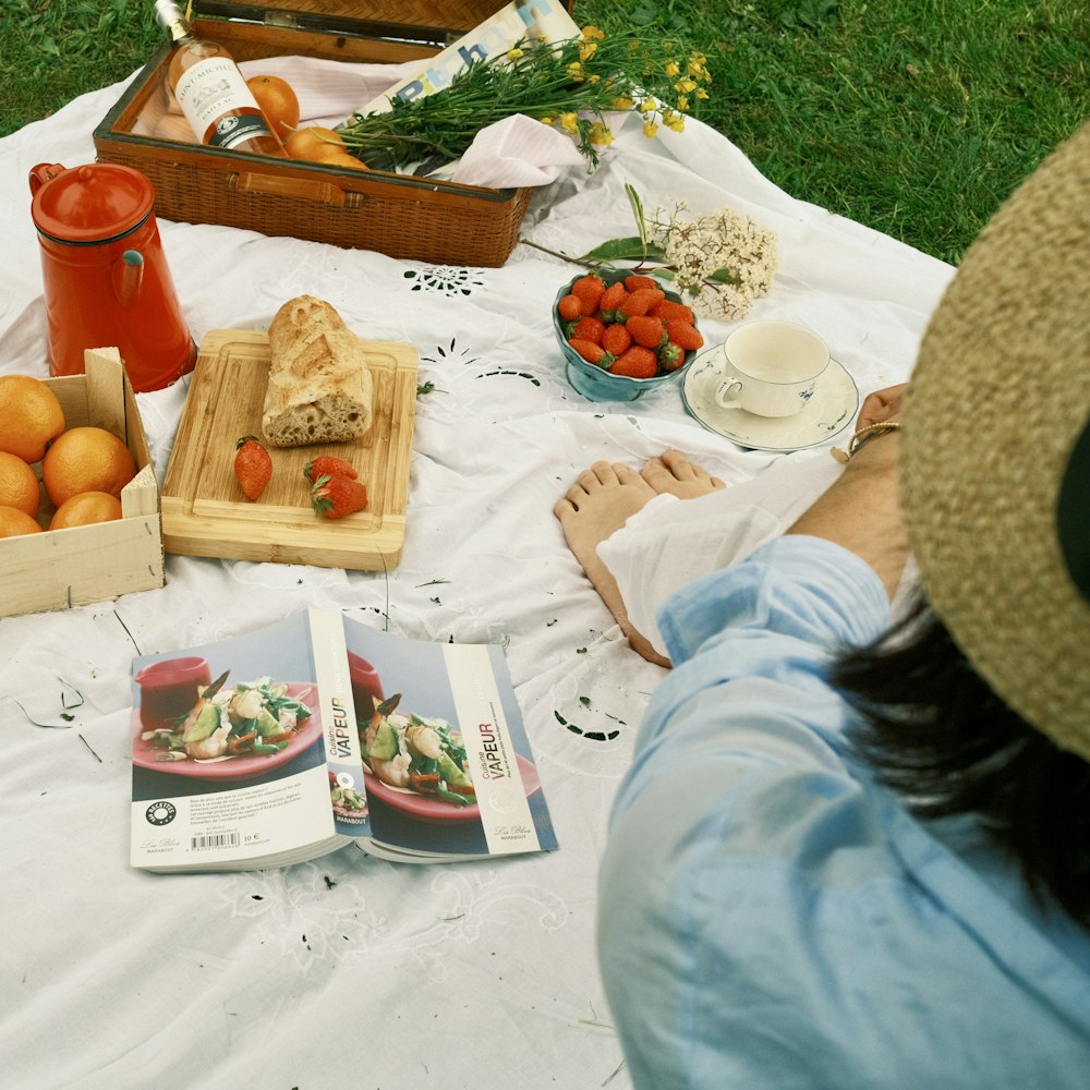 a woman sitting at a picnic table with food