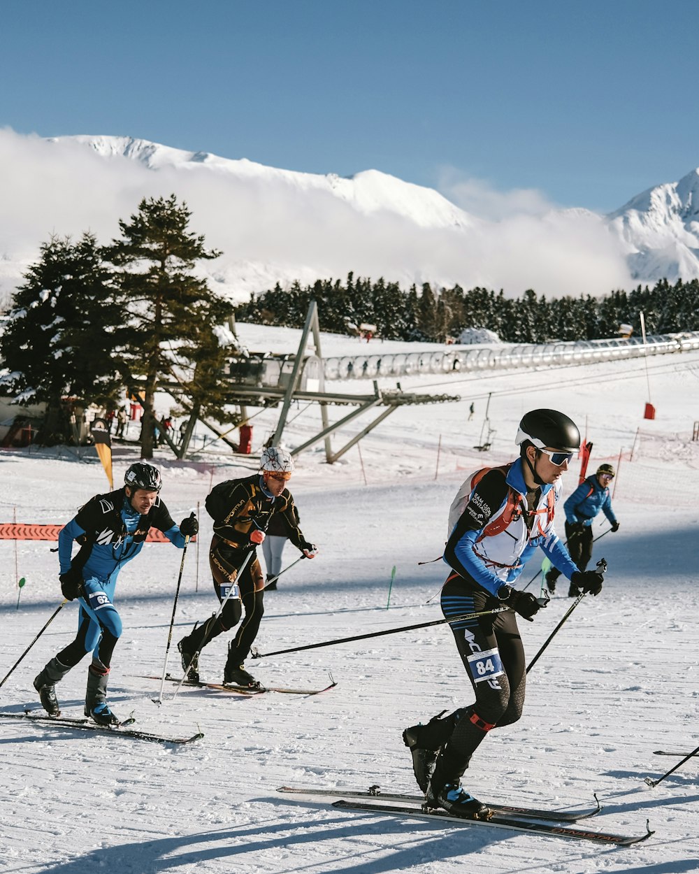 a group of people riding skis down a snow covered slope