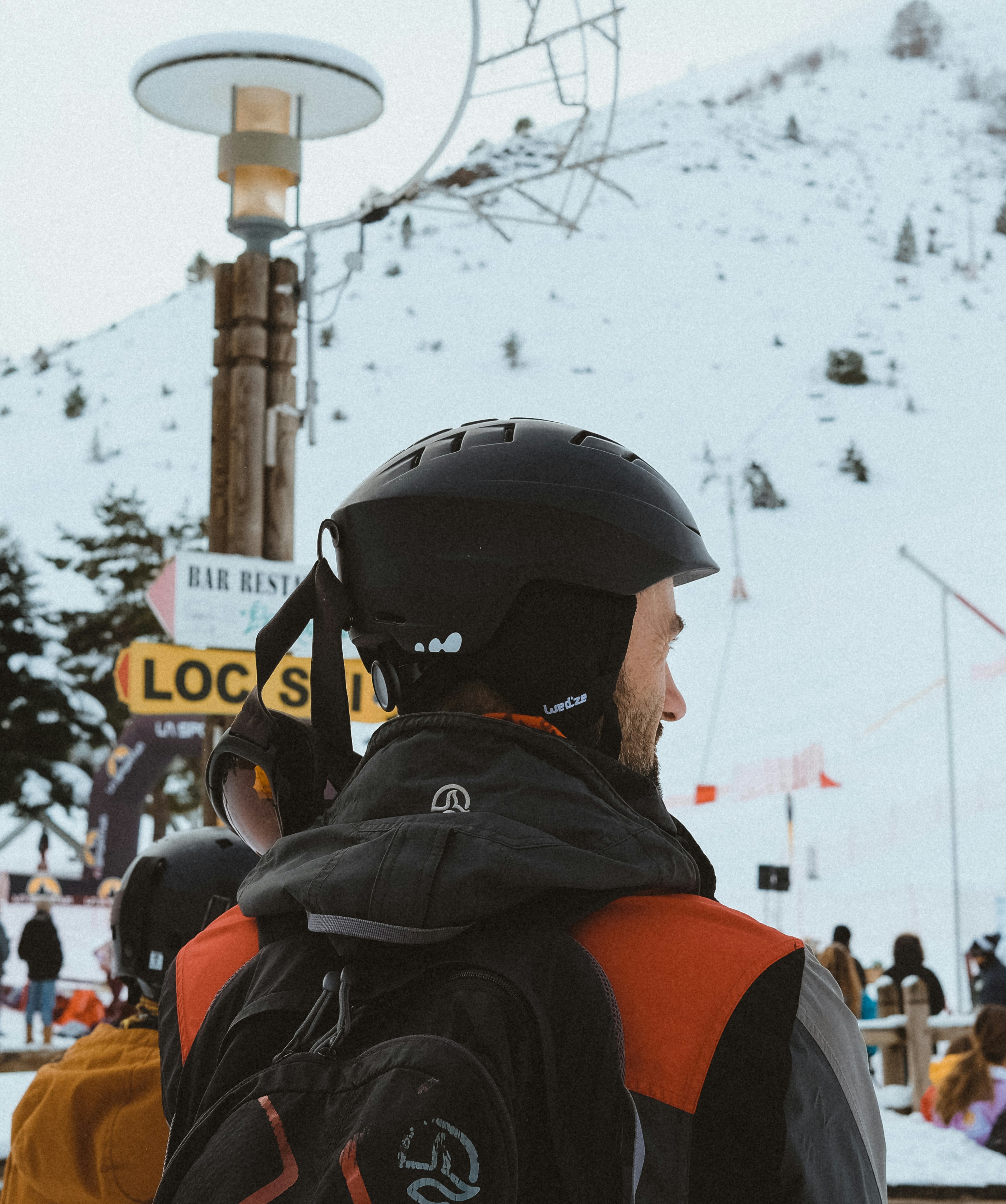 a man wearing a helmet standing in the snow