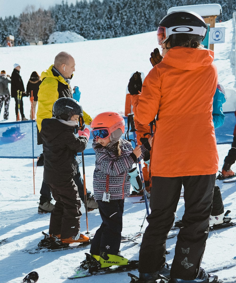 a group of people standing on top of a snow covered slope