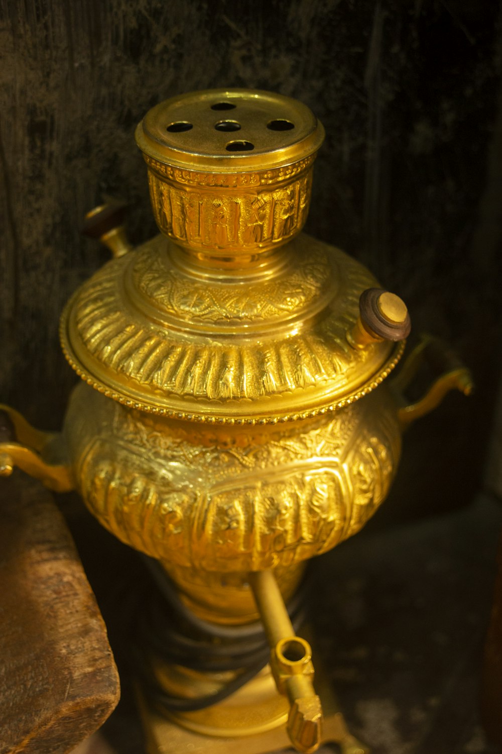 a gold vase with a pipe sticking out of it