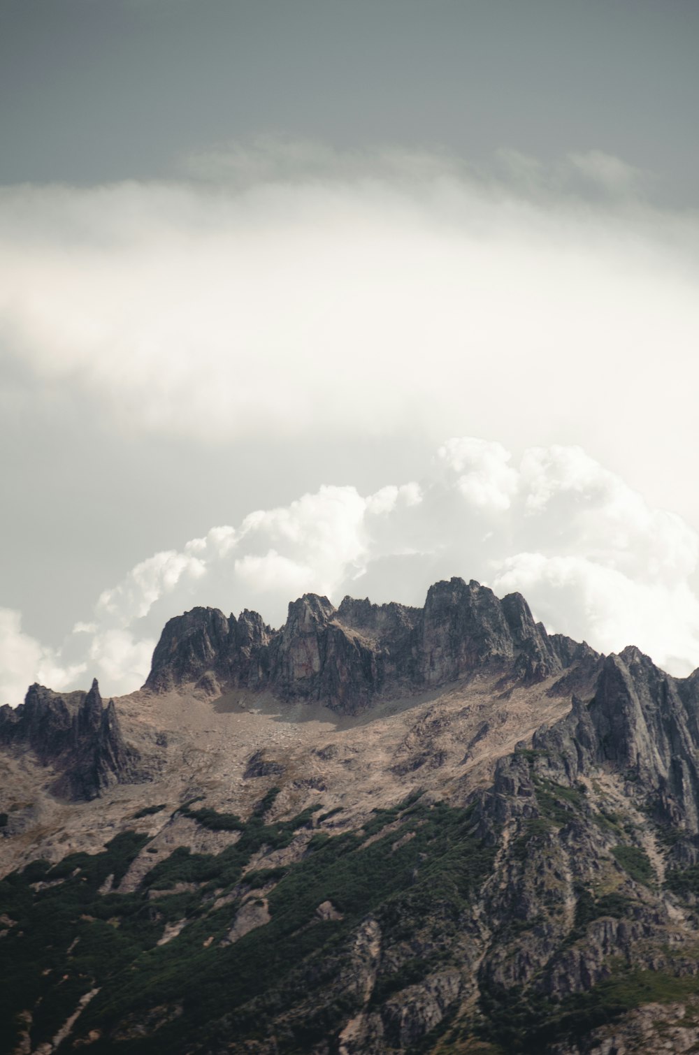 a mountain range with a few clouds in the sky