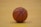 A close-up of a basketball resting on a wooden gym floor.