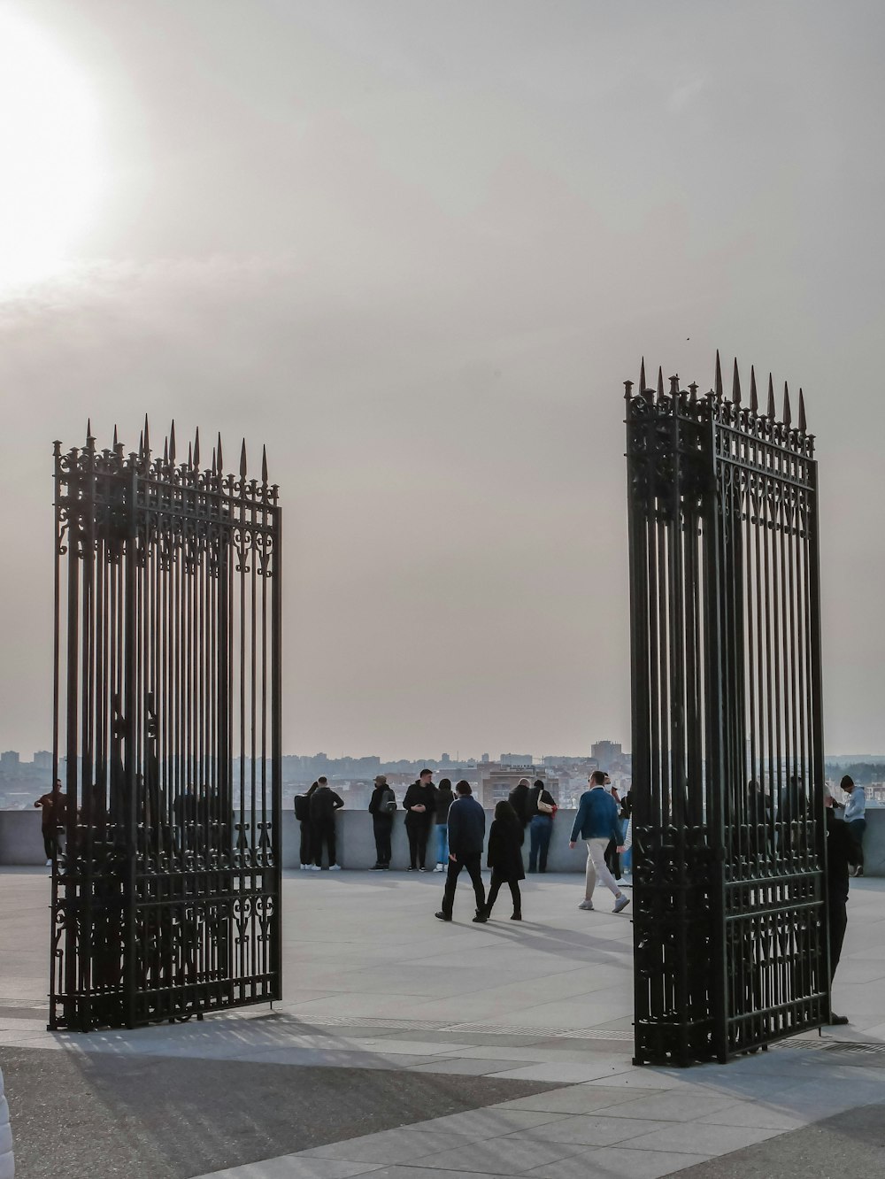 a group of people standing around a metal gate