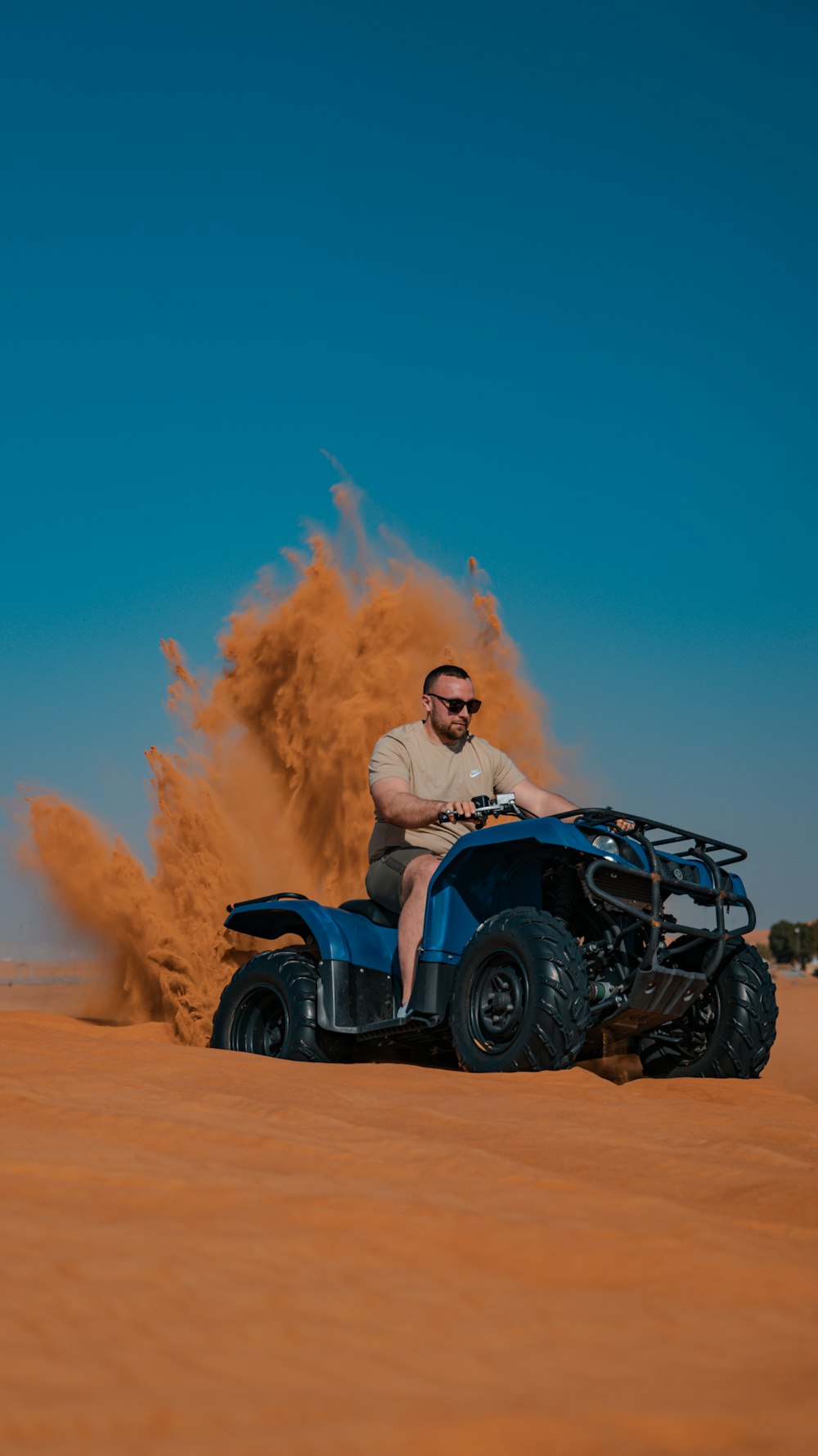 a man riding on the back of a blue four wheeler