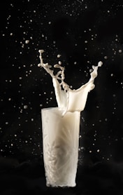 a milk splashing into a glass of milk
