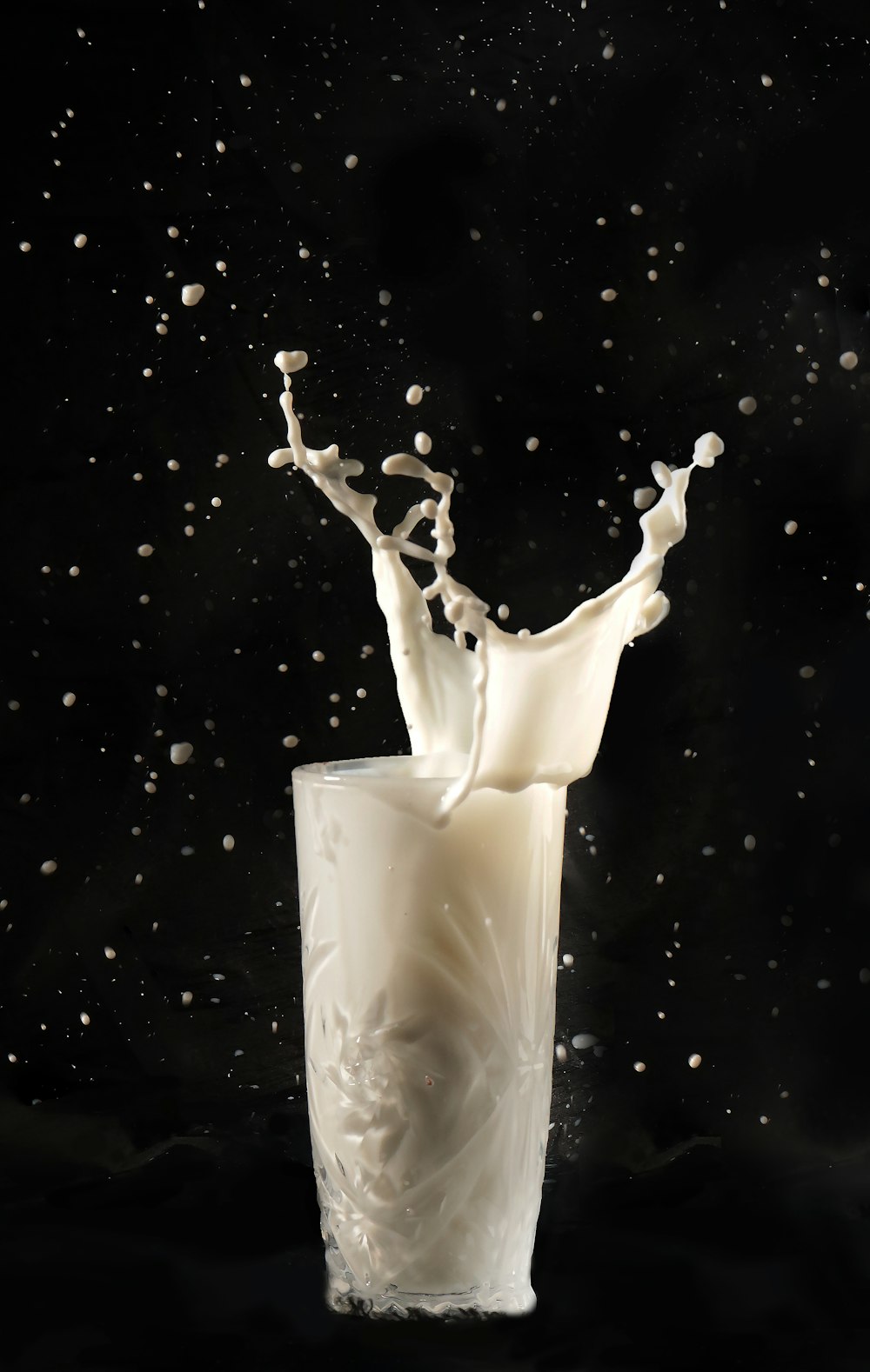 a milk splashing into a glass of milk