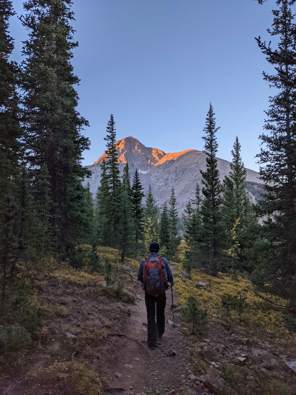 a man hiking up a trail in the mountains