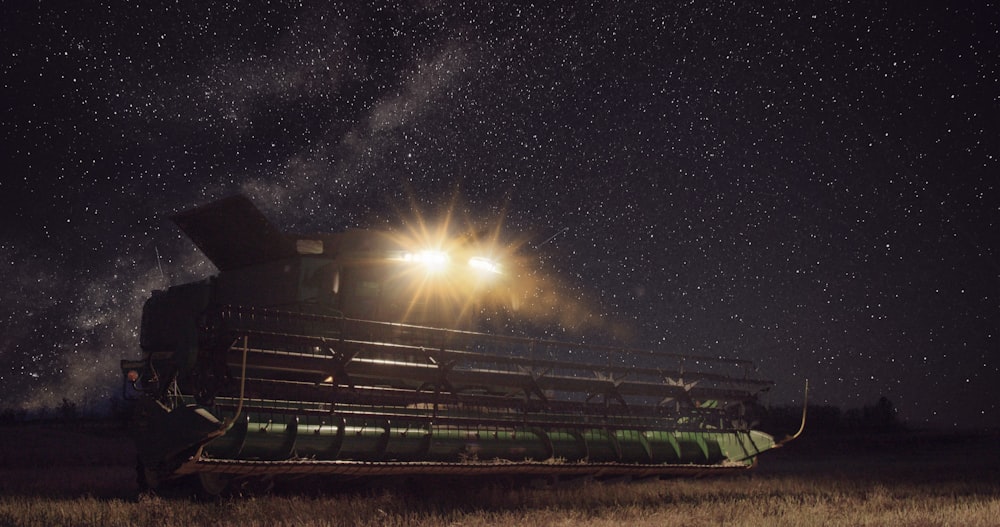 a grain harvester at night with the milky in the background