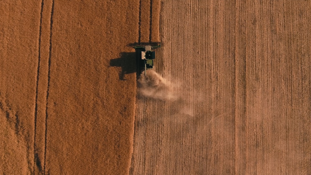 a tractor in a field spraying pesticide on crops