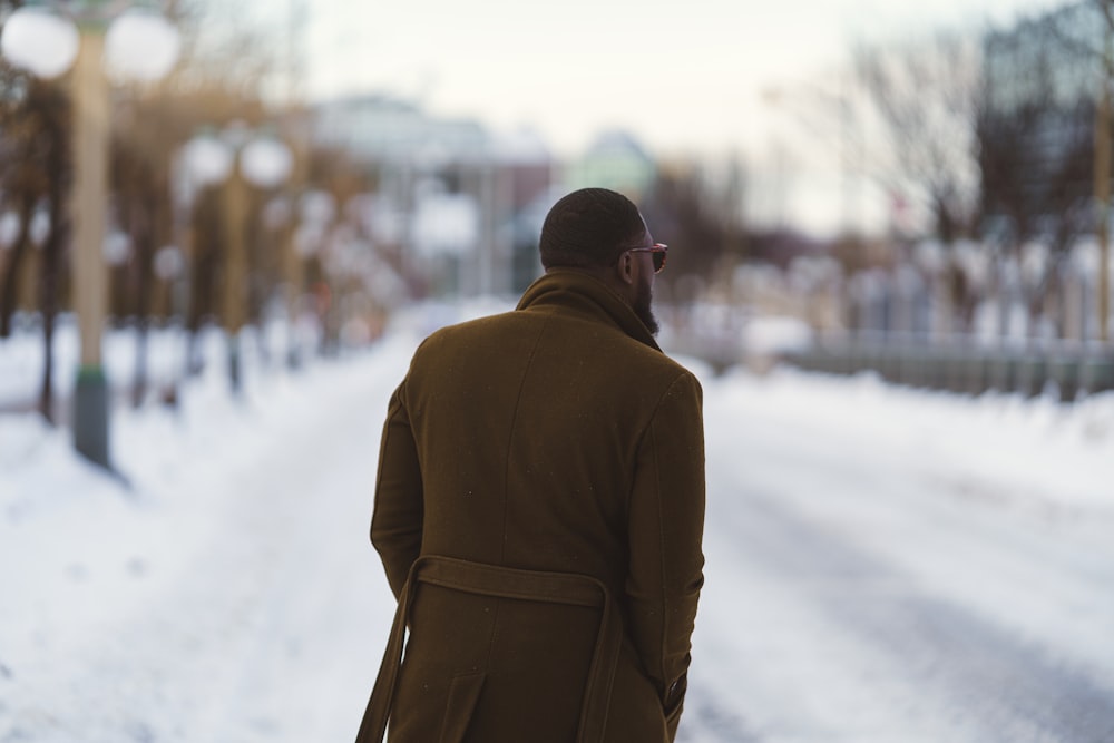 a man walking down a snow covered street