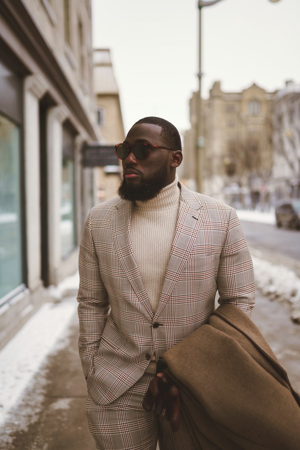 a man in a suit and sunglasses walking down the street