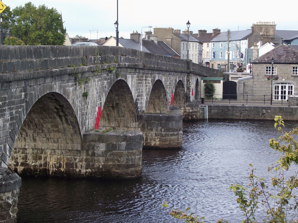 a bridge over a body of water with buildings in the background