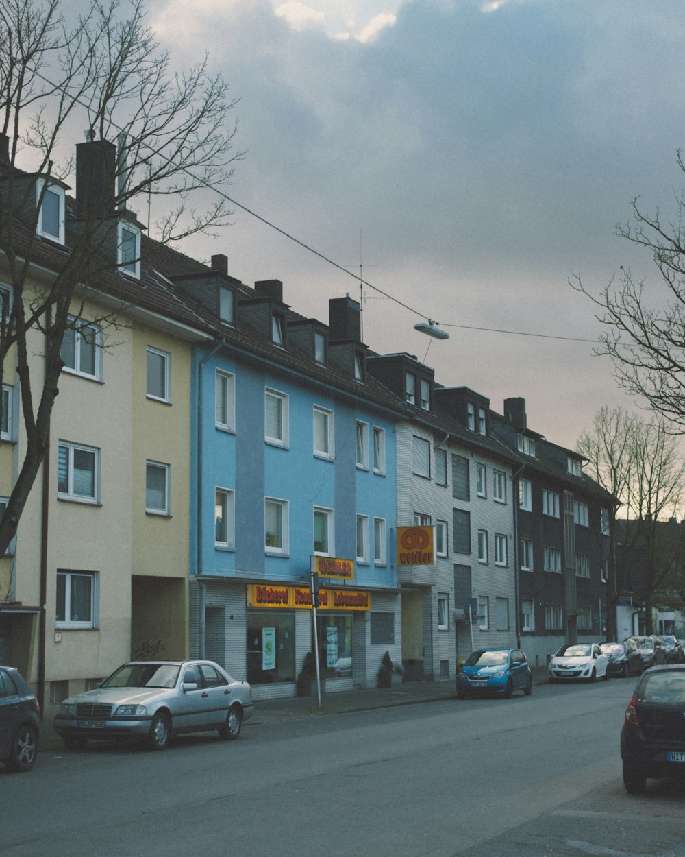 Eine Reihe von Häusern in einer Straße mit Autos, die am Straßenrand geparkt sind