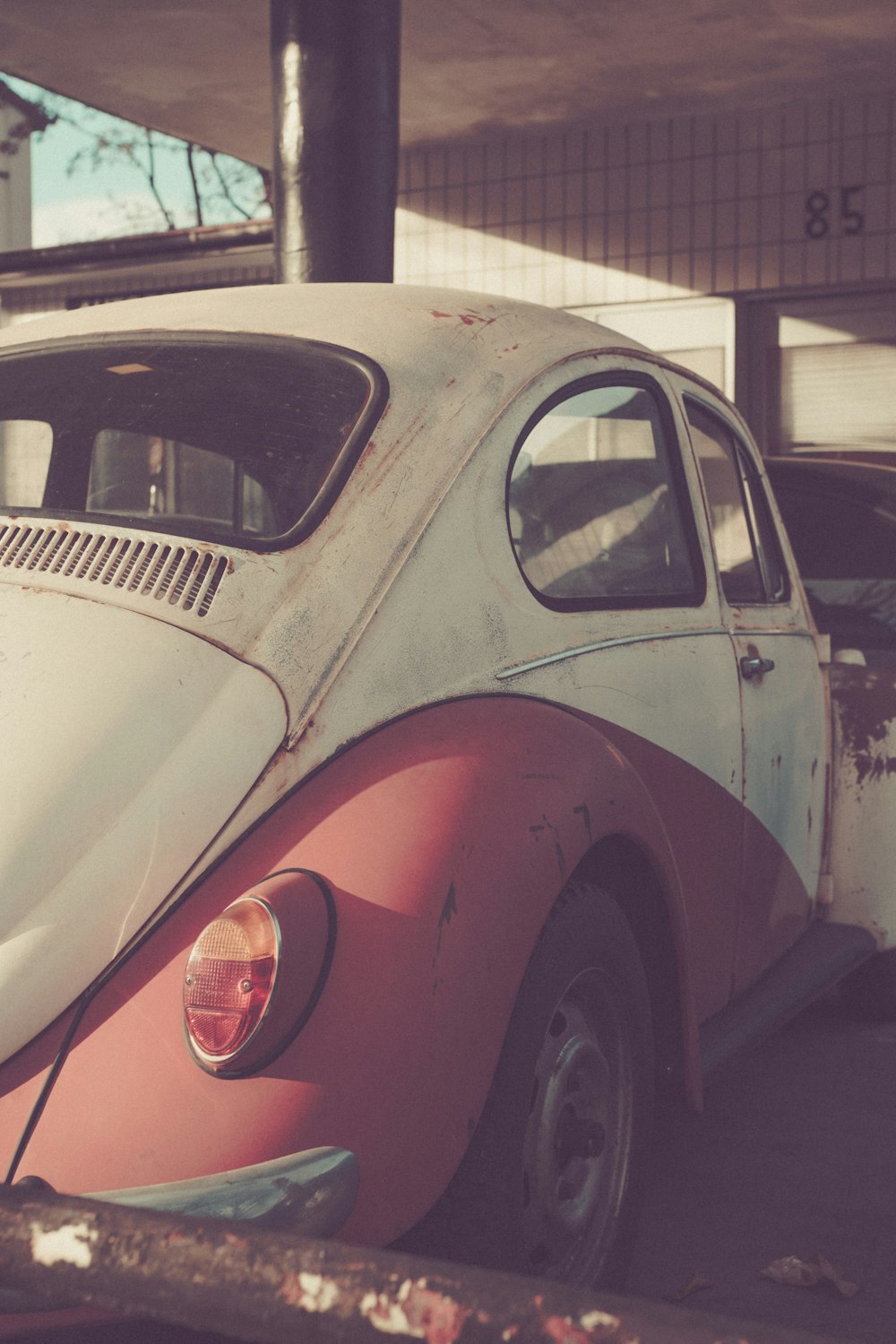 a red and white vw bug parked in a parking lot
