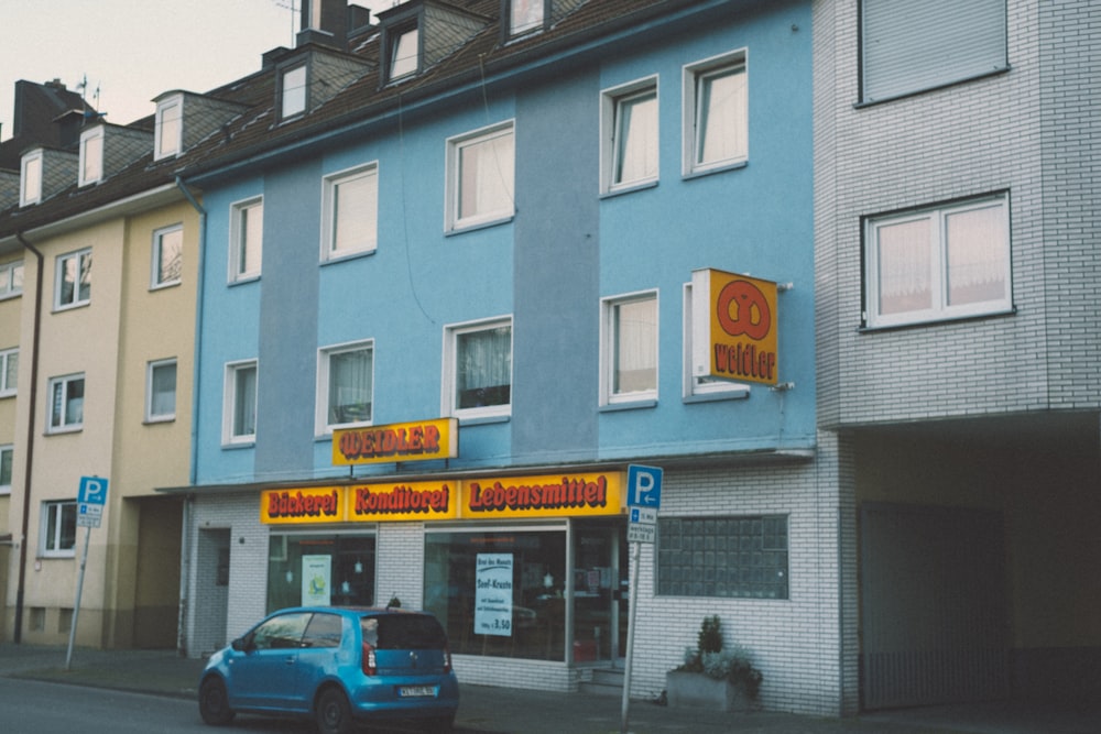 Ein blaues Auto parkt vor einem Gebäude