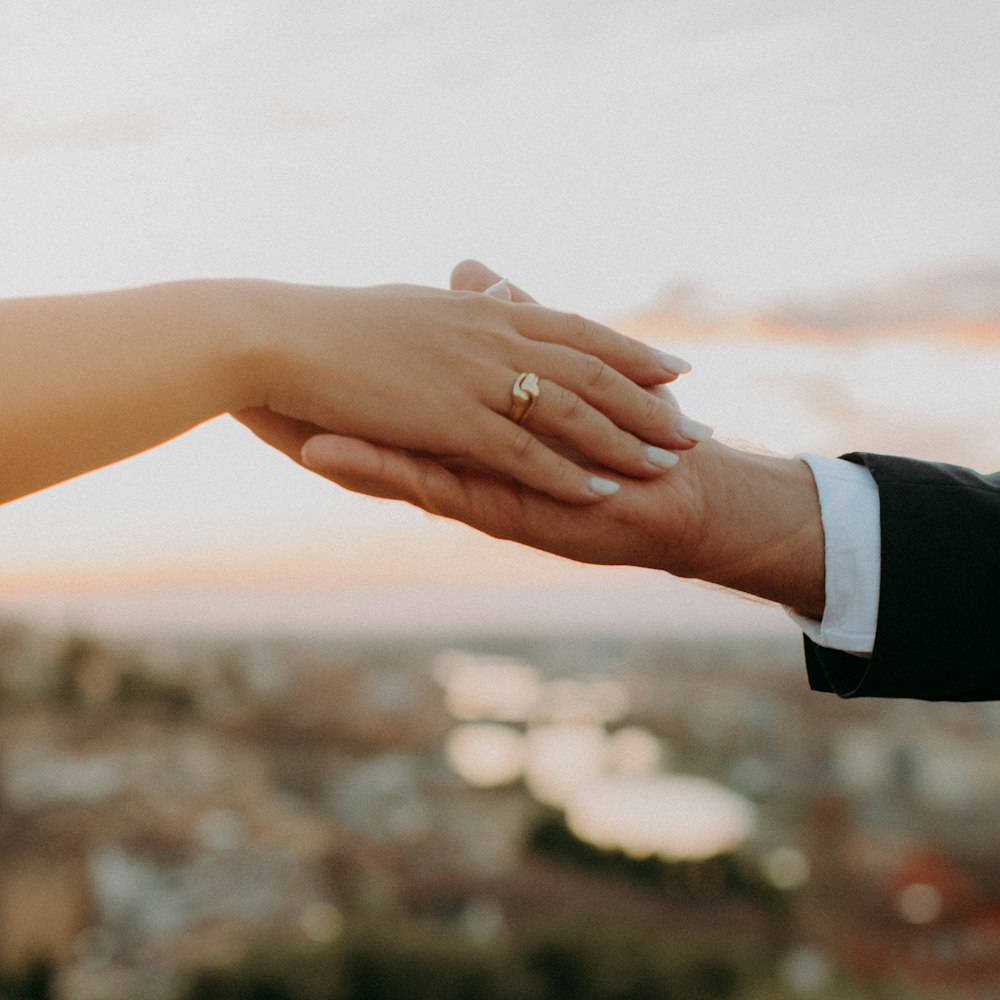 a close up of a person holding the hand of another person