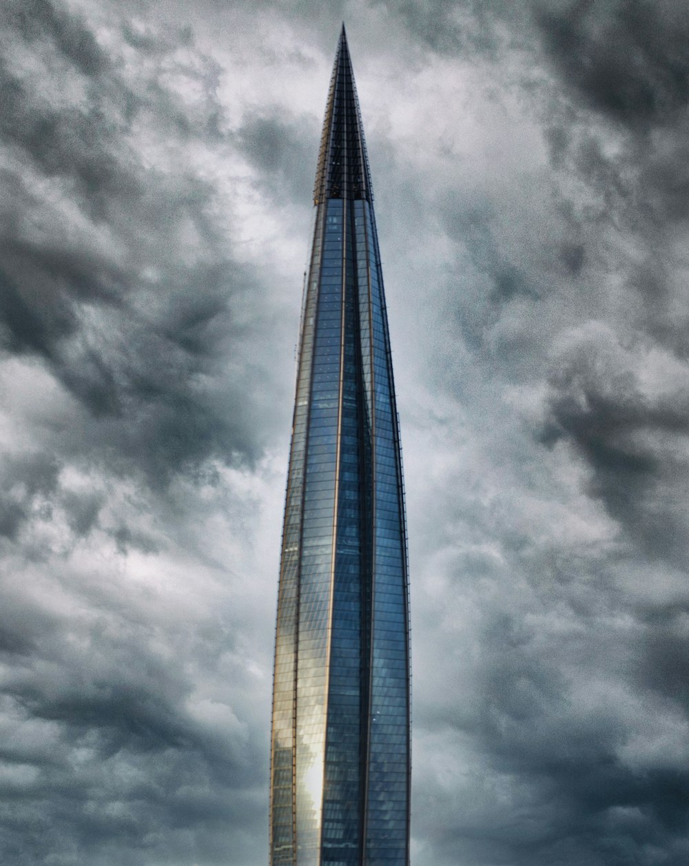 a very tall building sitting under a cloudy sky