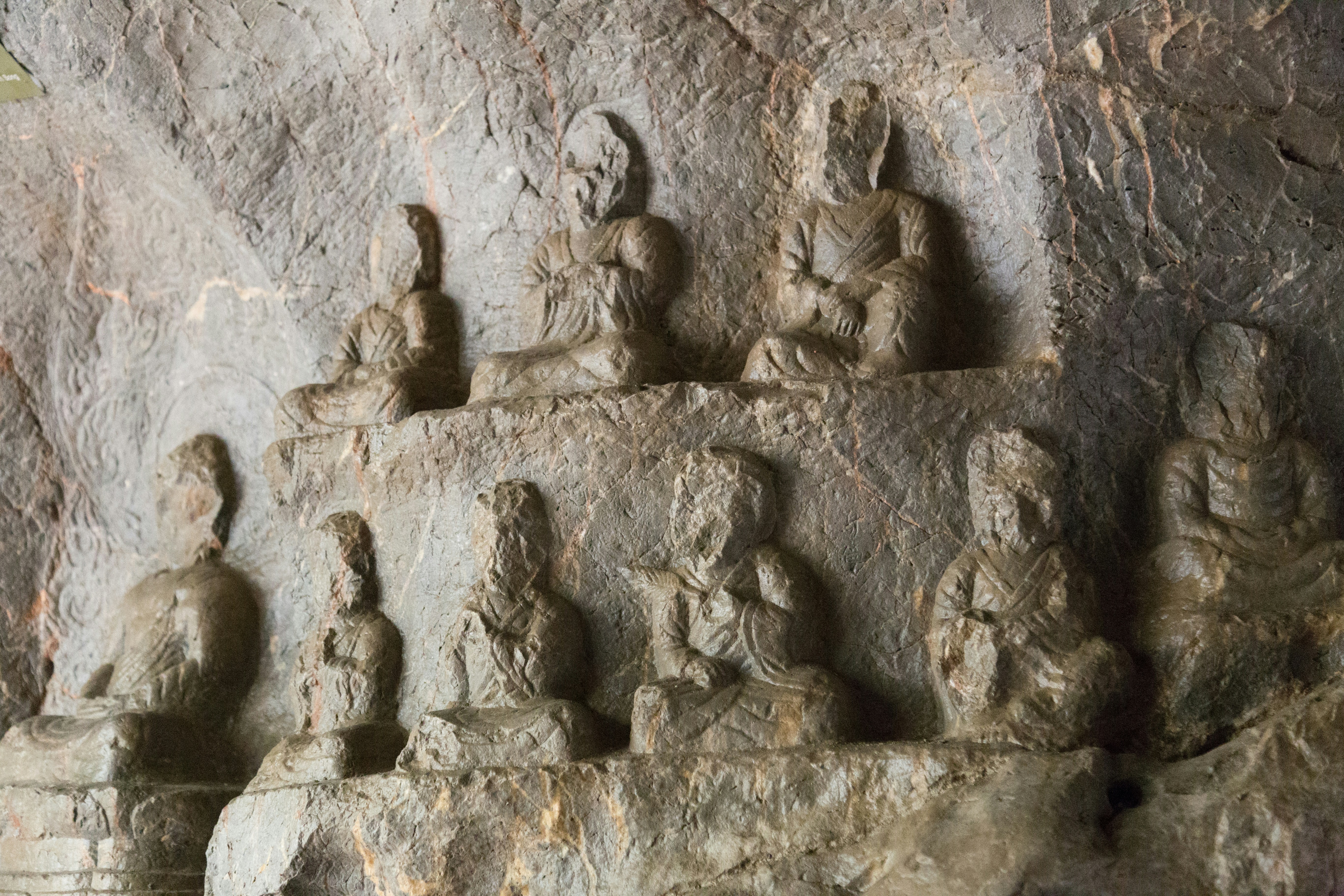 a group of statues sitting on top of a stone wall