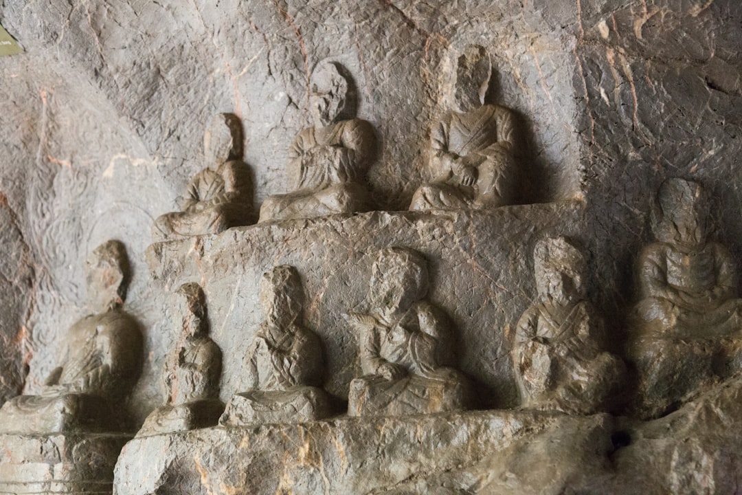 a group of statues sitting on top of a stone wall