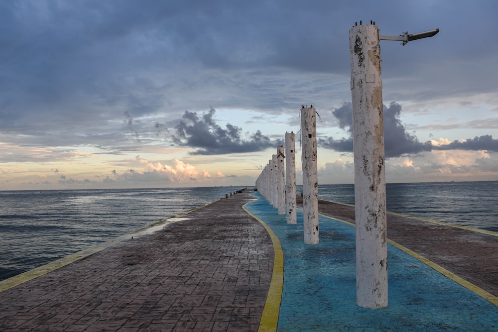 a pier with a few poles sticking out of the water