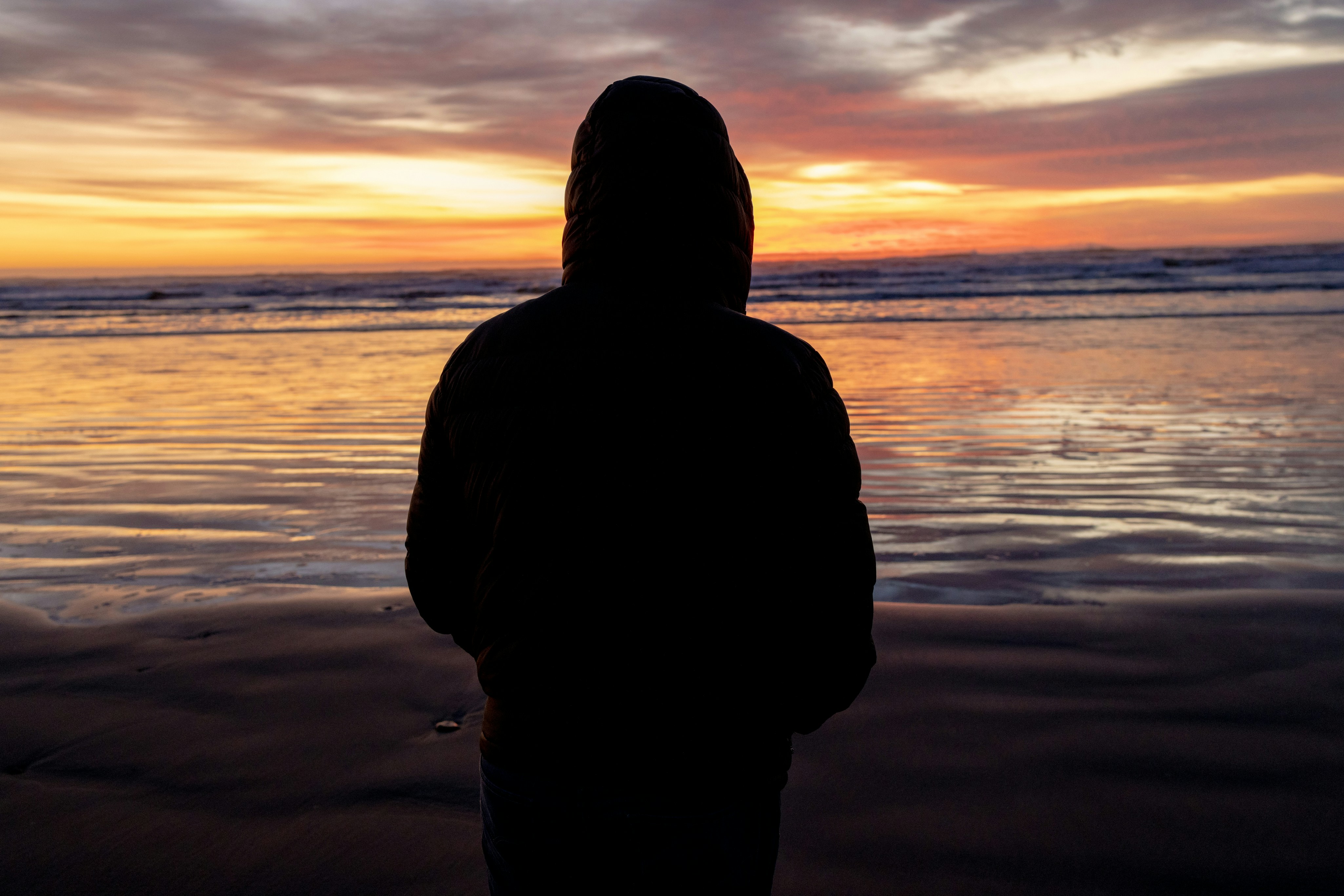 a person standing on a beach at sunset