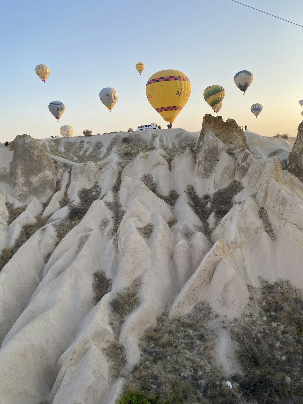 a group of hot air balloons flying over a mountain