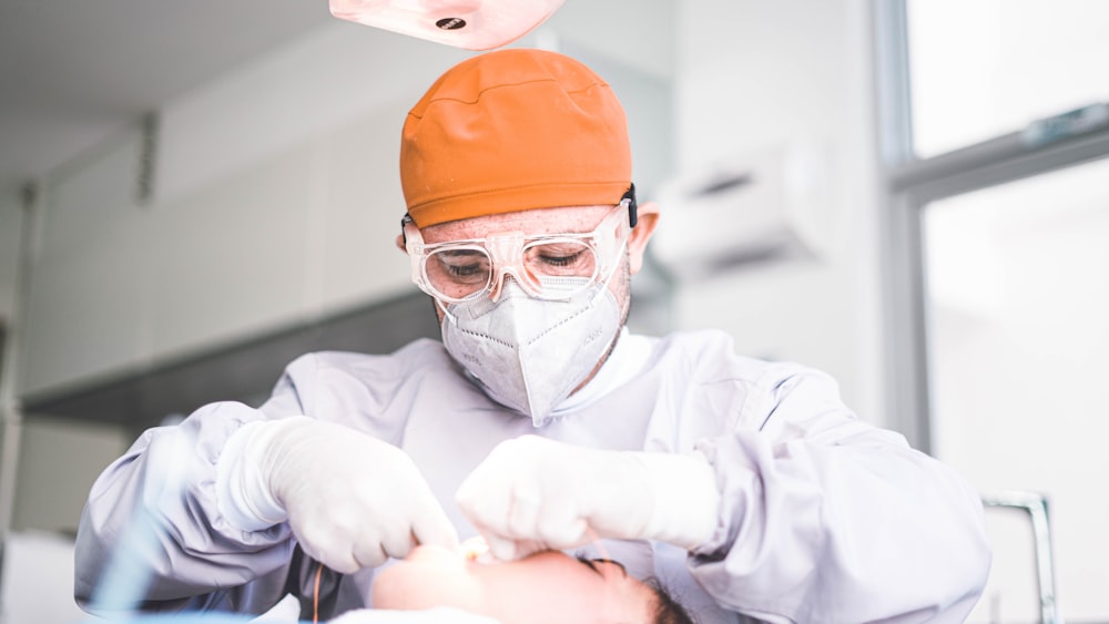 a man getting his teeth brushed by a dentist