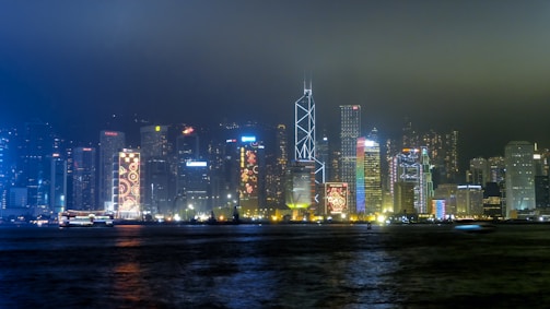 A night shot of a city skyline with glowing data streams overlay.