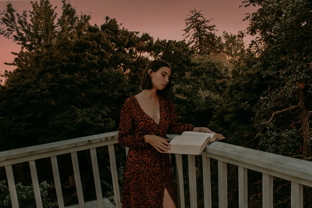 a woman standing on a balcony holding a box