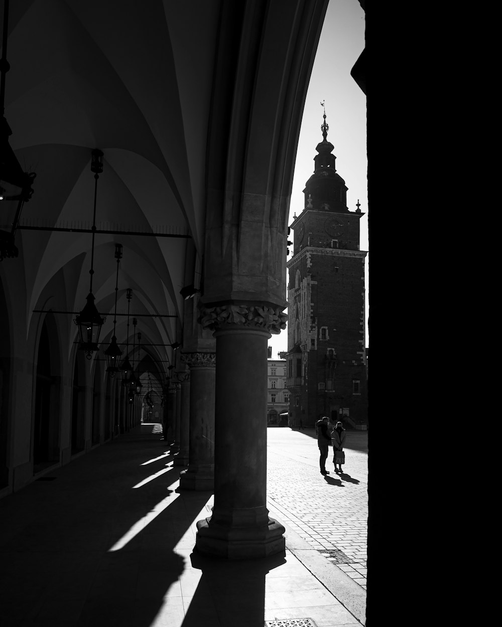 a black and white photo of a person walking down a street