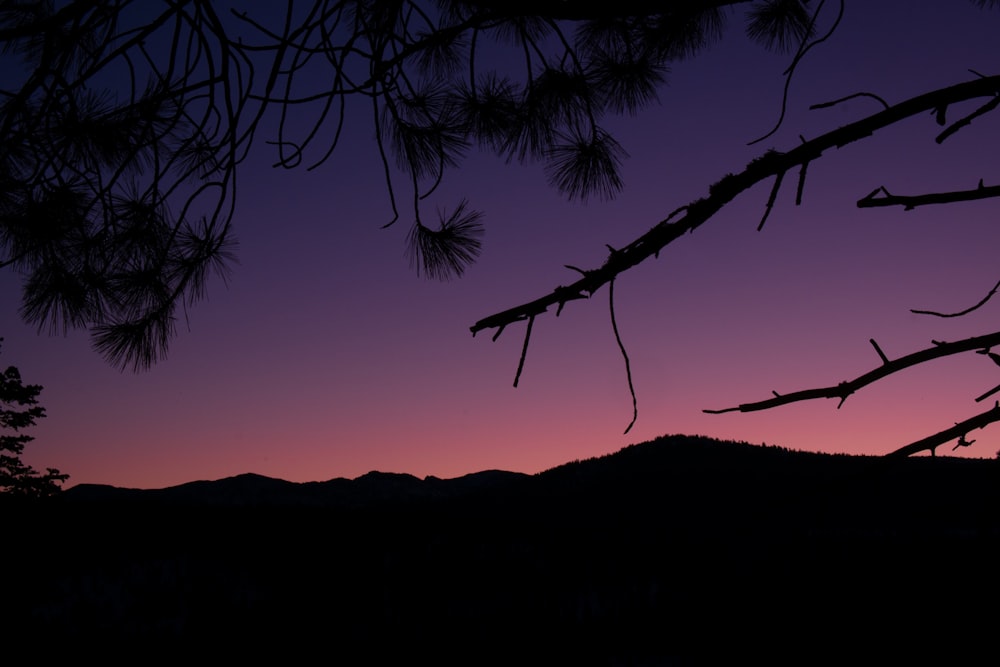 the sun is setting over a mountain range