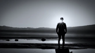 a man standing in front of a body of water