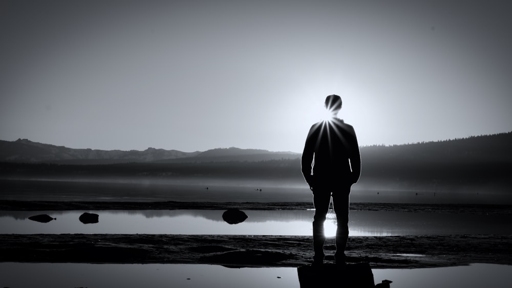 a man standing in front of a body of water