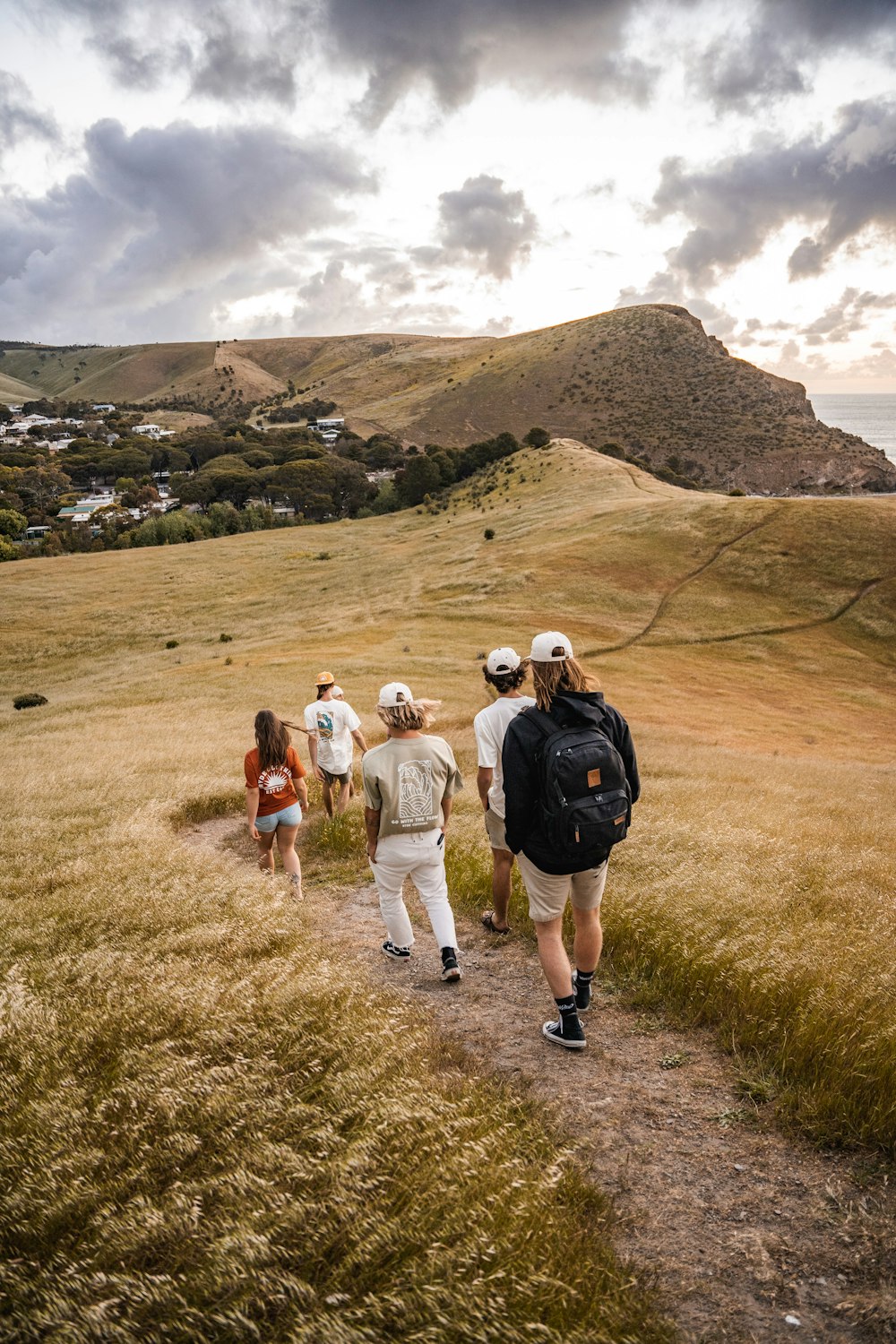 a group of people walking down a dirt road