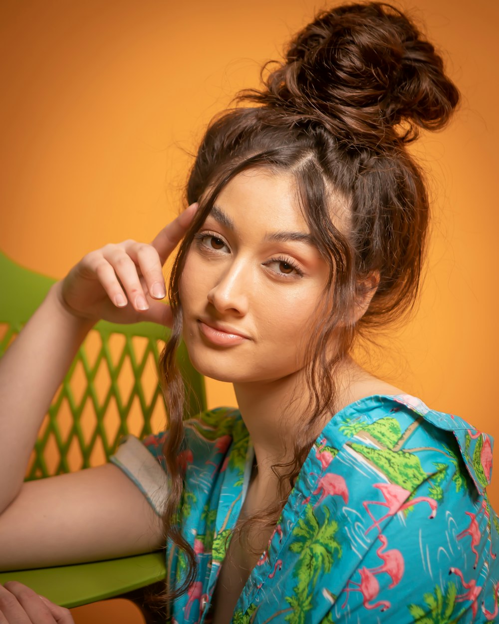 a woman sitting in a chair with her hair in a bun