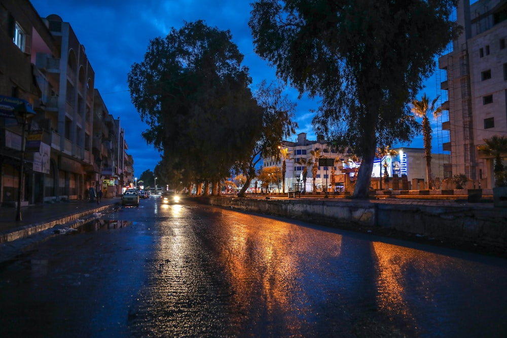 a city street at night with cars driving on it