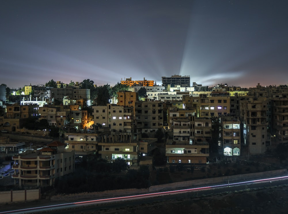 a city at night with a light streaking through the sky