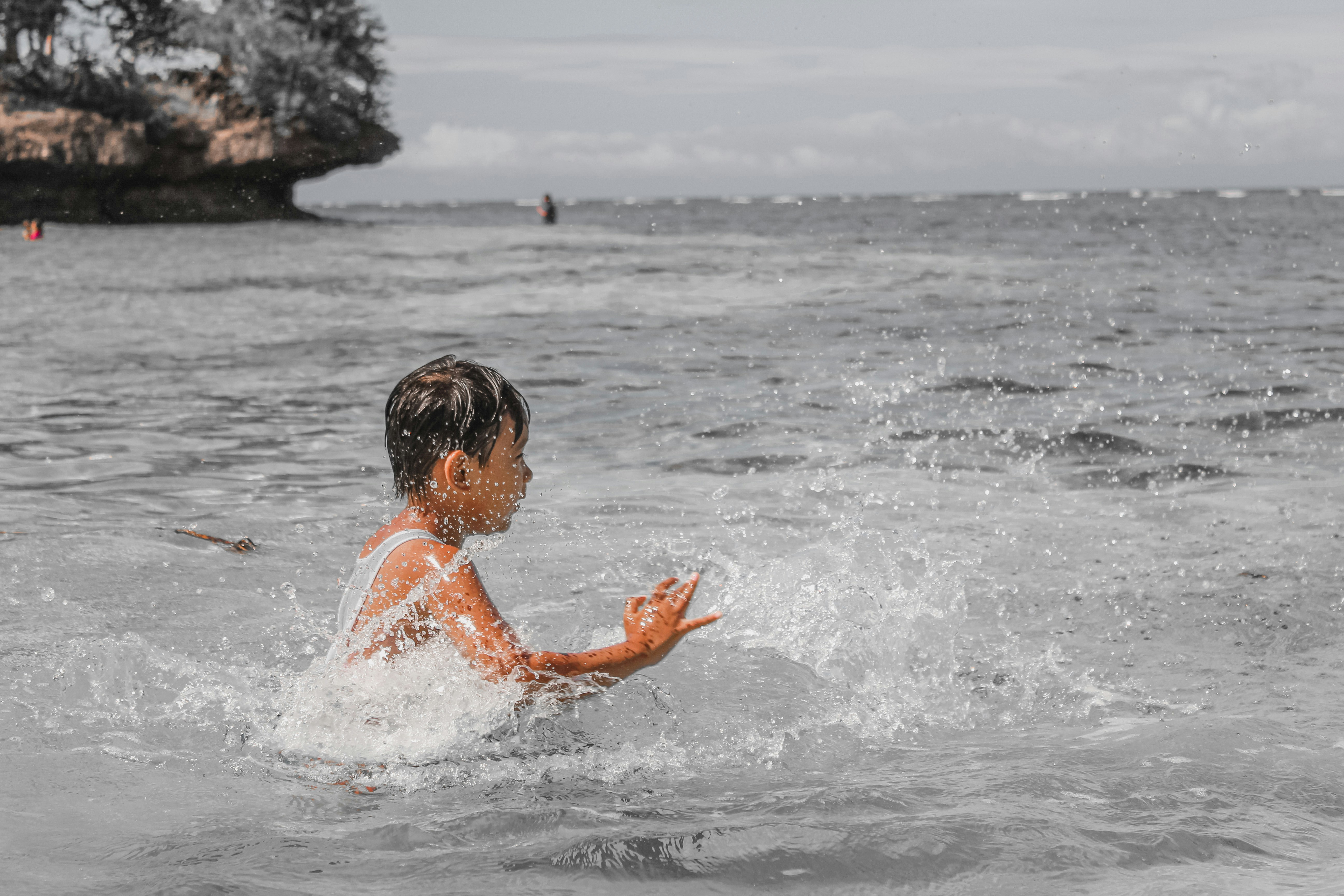a young boy playing in the ocean water