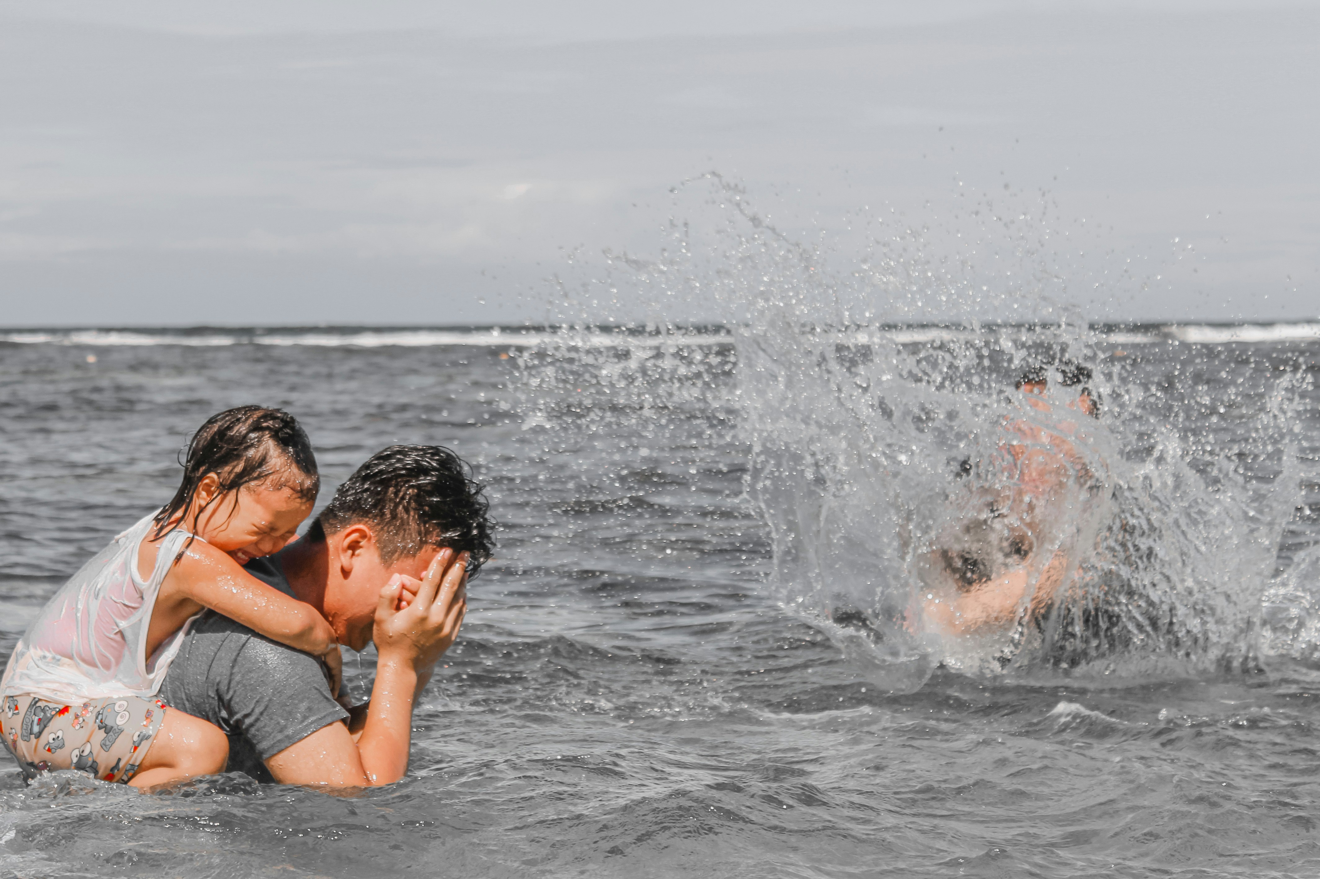 a man and a little girl playing in the water
