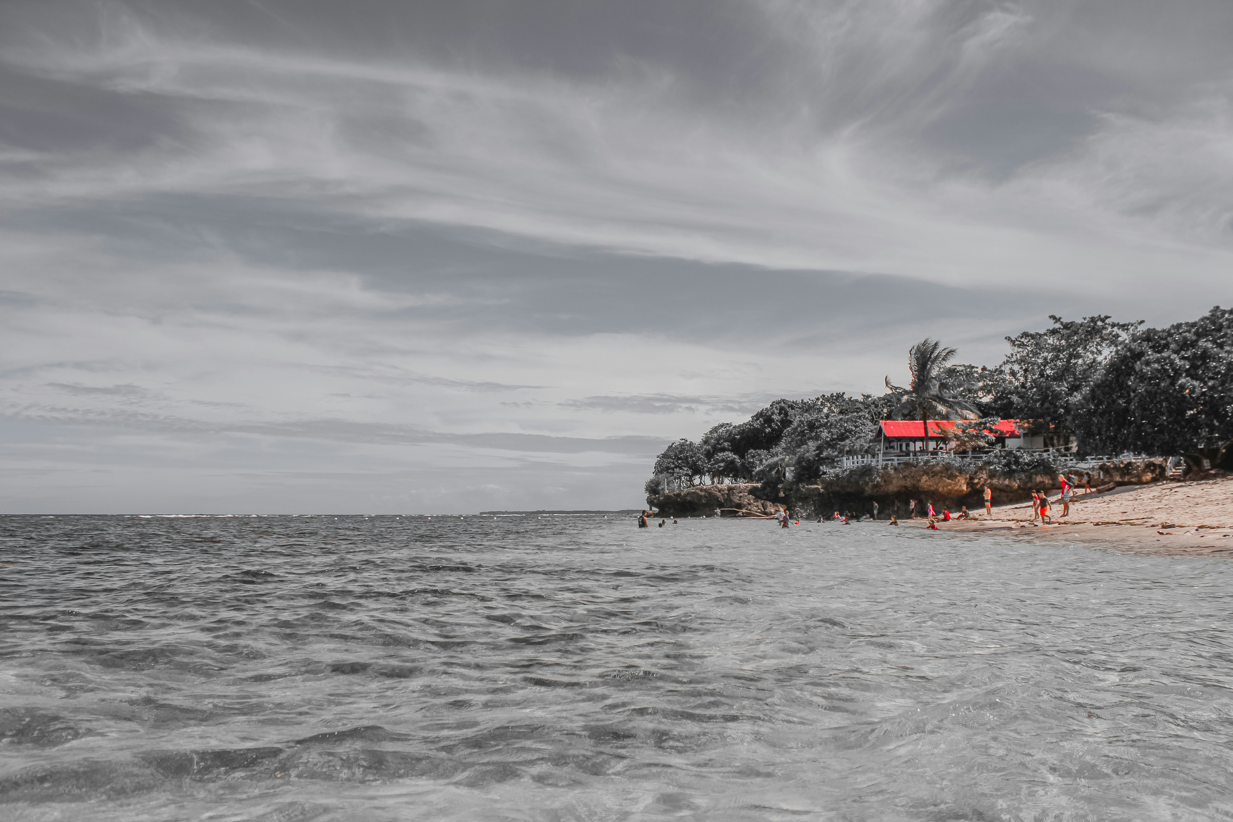 a beach with a house on a small island in the middle of the ocean